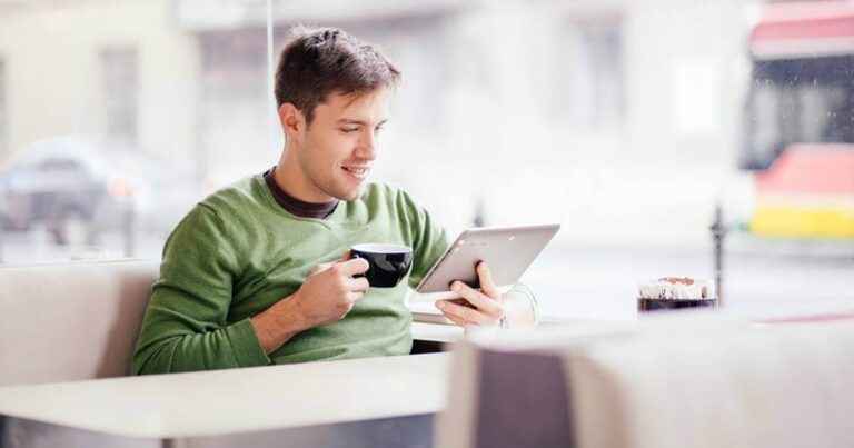 Administrador tomando café e lendo sobre funções administrativas em um tablet.