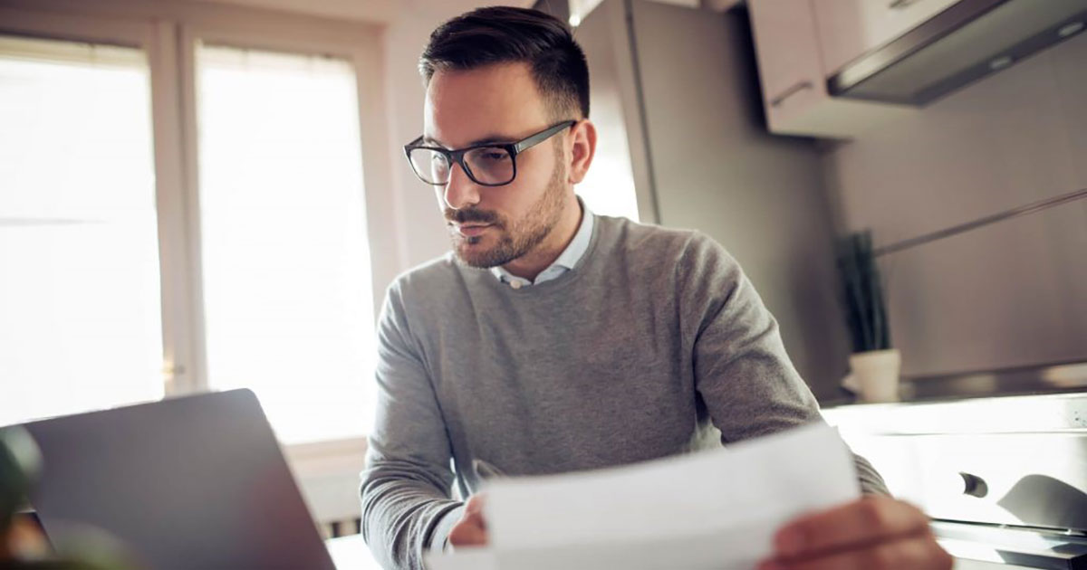 Homem analisando papéis em seu escritório