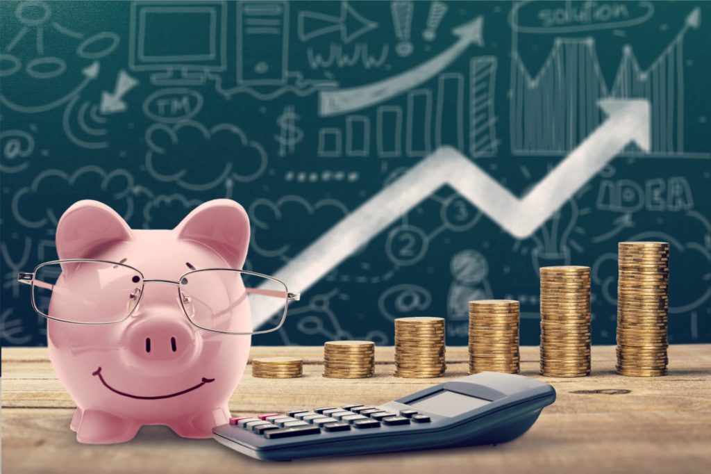 Porquinho de óculos ao lado de moedas representando melhorias na saúde financeira de um negócio